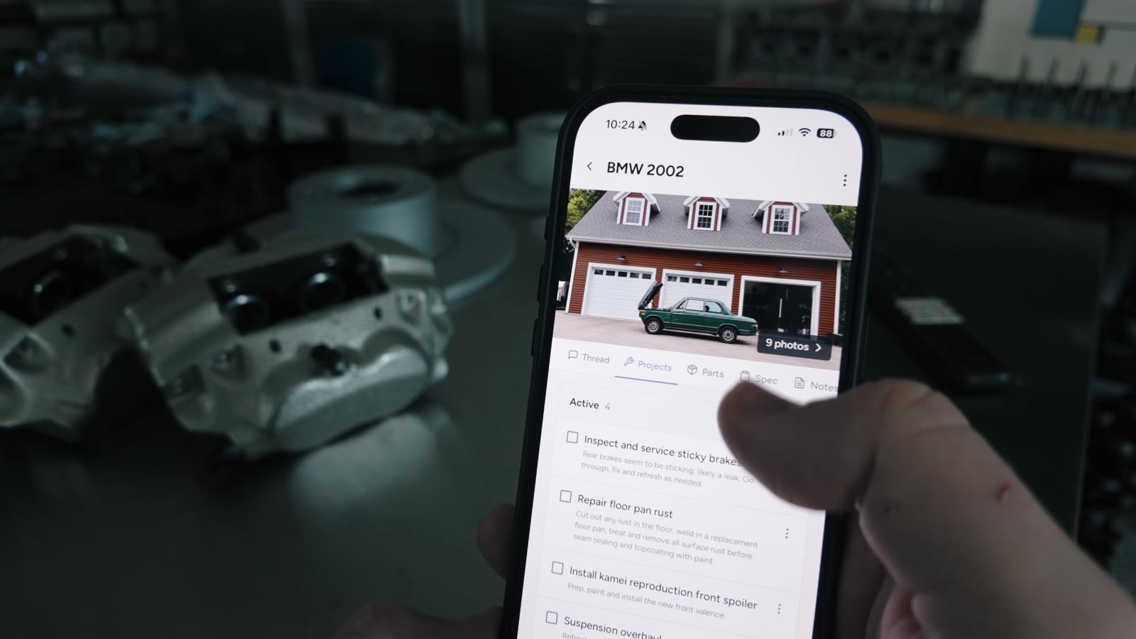 Assembly on an iPhone in a garage, showing a BMW 2002 project and its tasks